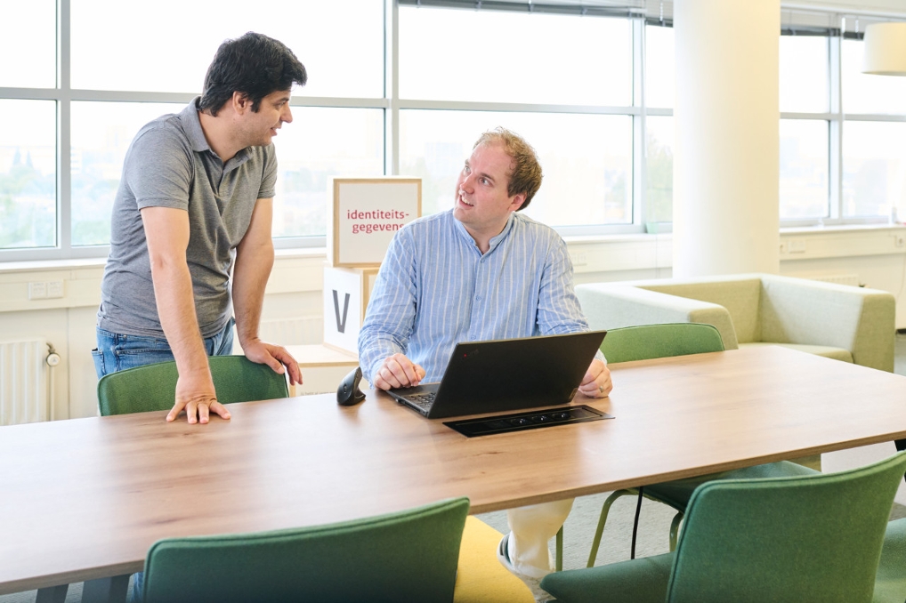 Tester Gafari Oguz en testmanager Kevin Goedee in gesprek bij de Rijksdienst voor Identiteitsgegevens