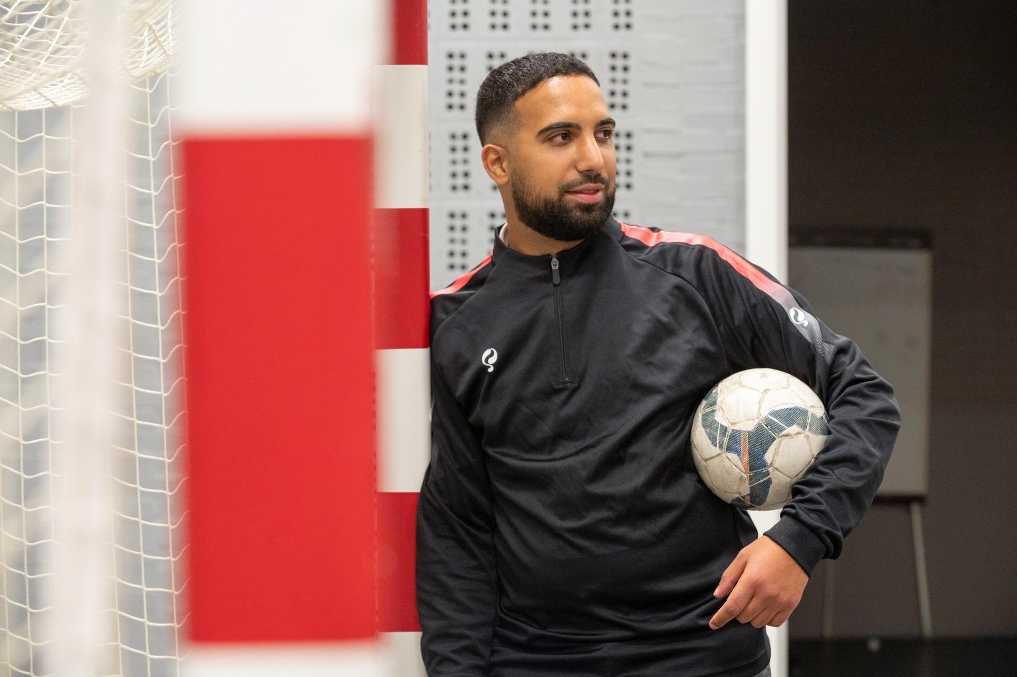 Oussama met voetbal onder arm in voetbalzaal