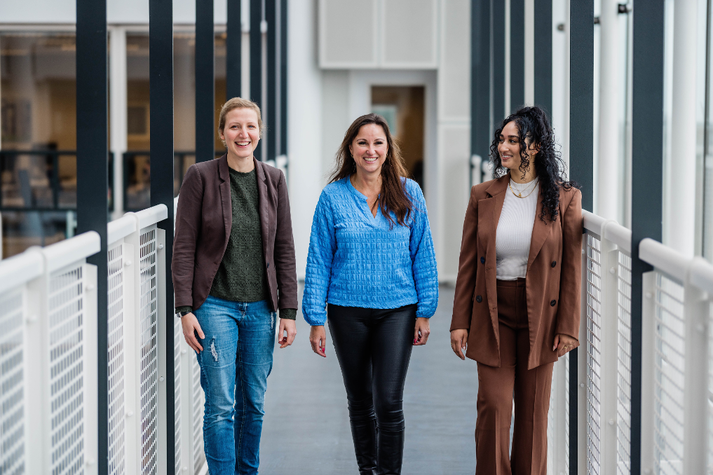 3 collega's wandelend door de gang. Zij zijn inkoopadviseur bij het ministerie van IenW