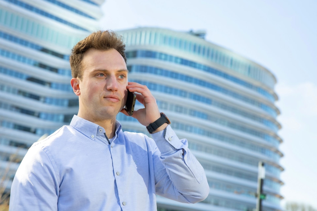 Maarten aan de telefoon buiten bij DUO