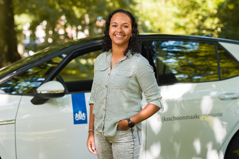 Kathy Anthony voor haar bedrijfsauto. Zij is ambulant objectleider bij de Rijksschoonmaakorganisatie