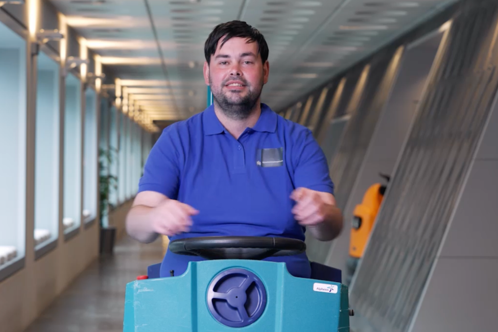 Portret van een collega bij de Rijksschoonmaakorganisatie, op een boenmachine