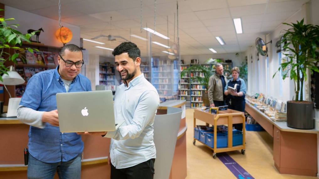 Functioneel beheerder Murat overlegt met een collega bij DJI