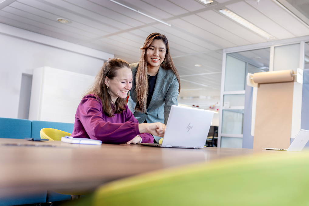 Portret van Isabelle Le. Ze is jurist bij de Rijksoverheid en in gesprek met een collega